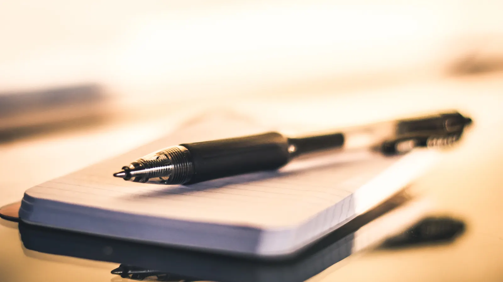 Pen resting on a notebook in warm light