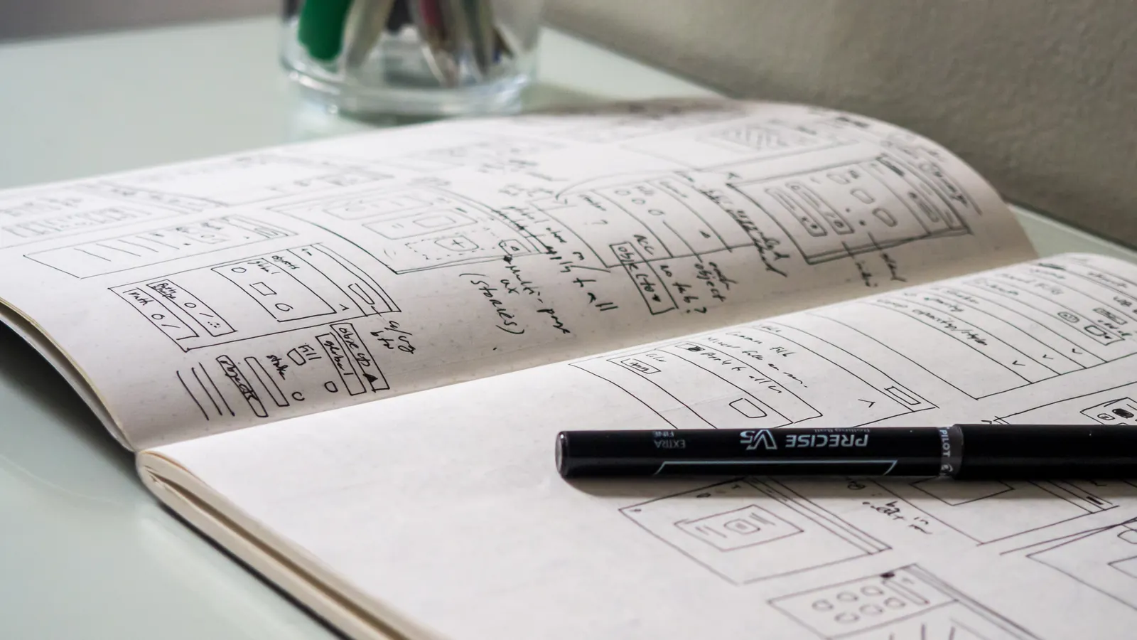 Open notebook with sketches and a pen