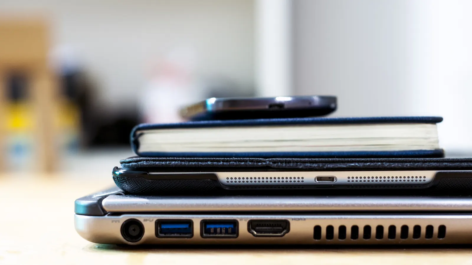 Smartphone, tablet and laptop stacked on a desk